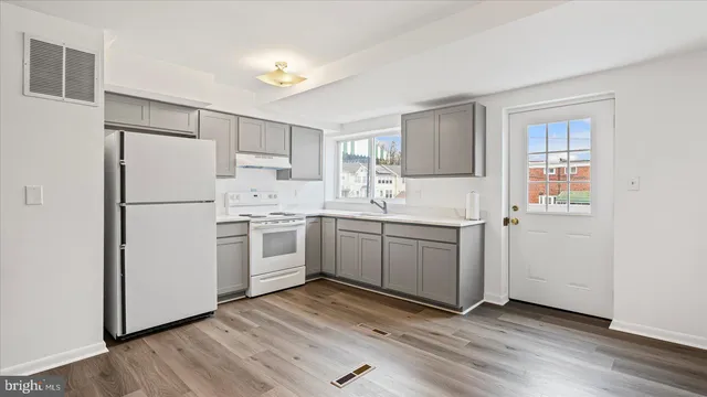 a kitchen with white cabinets and white appliances
