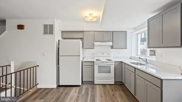 a kitchen with a sink a refrigerator a microwave and cabinets