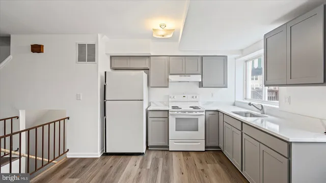 a kitchen with a sink a refrigerator a microwave and cabinets
