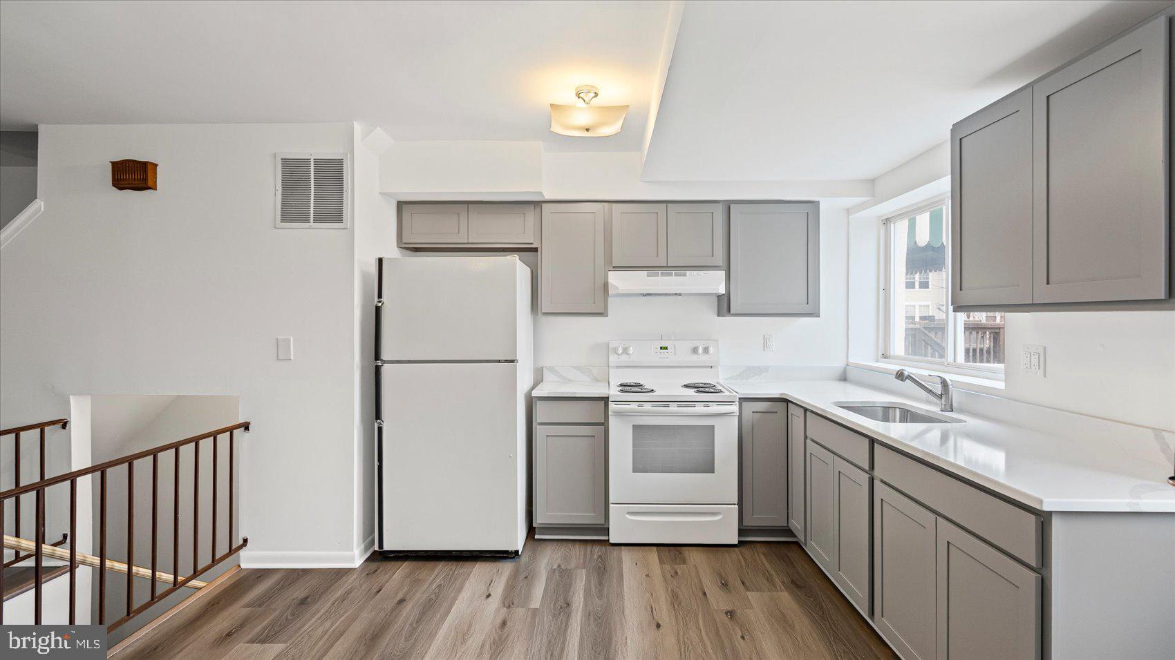 1408 Locust Street Curtis Bay, MD 21226 - Photo 9 of 35 a kitchen with a sink a refrigerator a microwave and cabinets