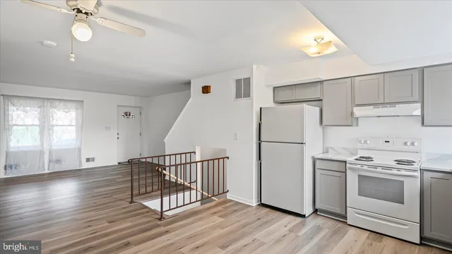 a kitchen with white cabinets and white appliances