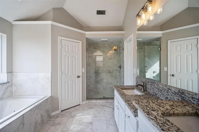 a bathroom with a granite countertop sink a toilet and shower