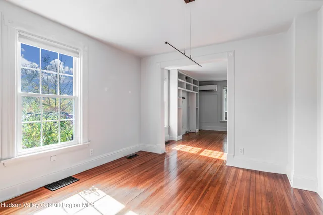 a view of hallway with wooden floor and window