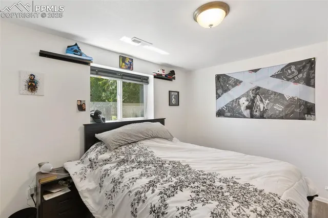 a bedroom with a bed and a large window