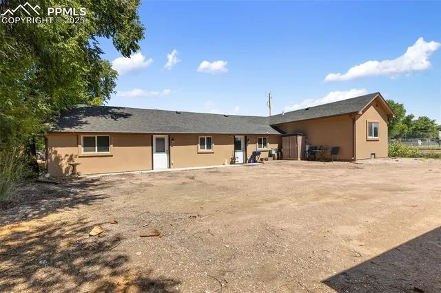 a view of a house with a patio and a yard