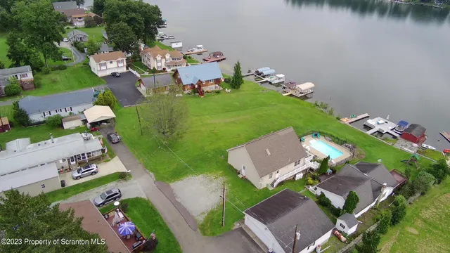 an aerial view of a house with garden space and lake view