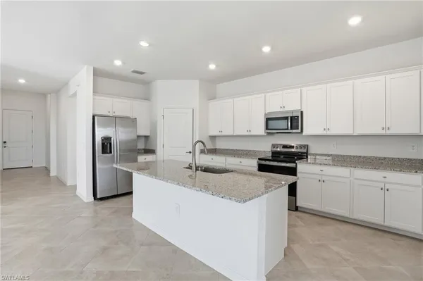 a kitchen with stainless steel appliances granite countertop a sink and a refrigerator