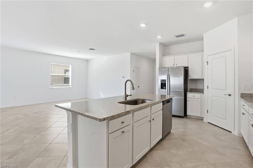 3958 Button Sage Road Alva, FL 33920 - Photo 49 of 50 a kitchen with stainless steel appliances granite countertop a sink and a refrigerator