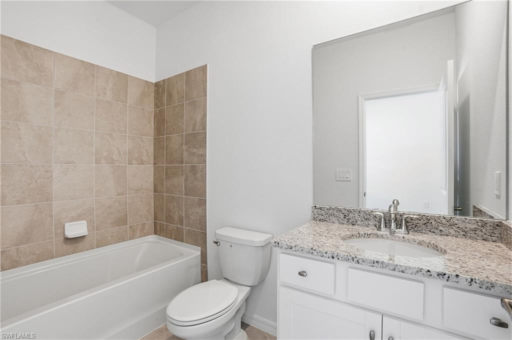 3958 Button Sage Road Alva, FL 33920 - Photo 23 of 50 a bathroom with a granite countertop sink a toilet and bathtub