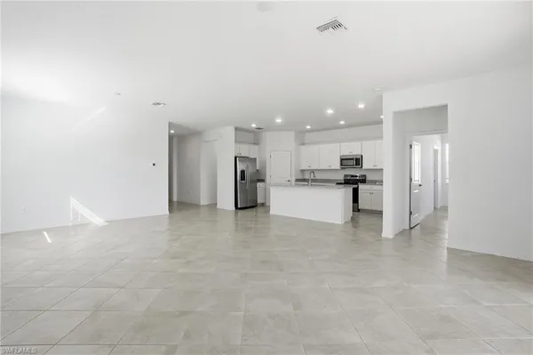 a view of kitchen with stainless steel appliances refrigerator oven and cabinets