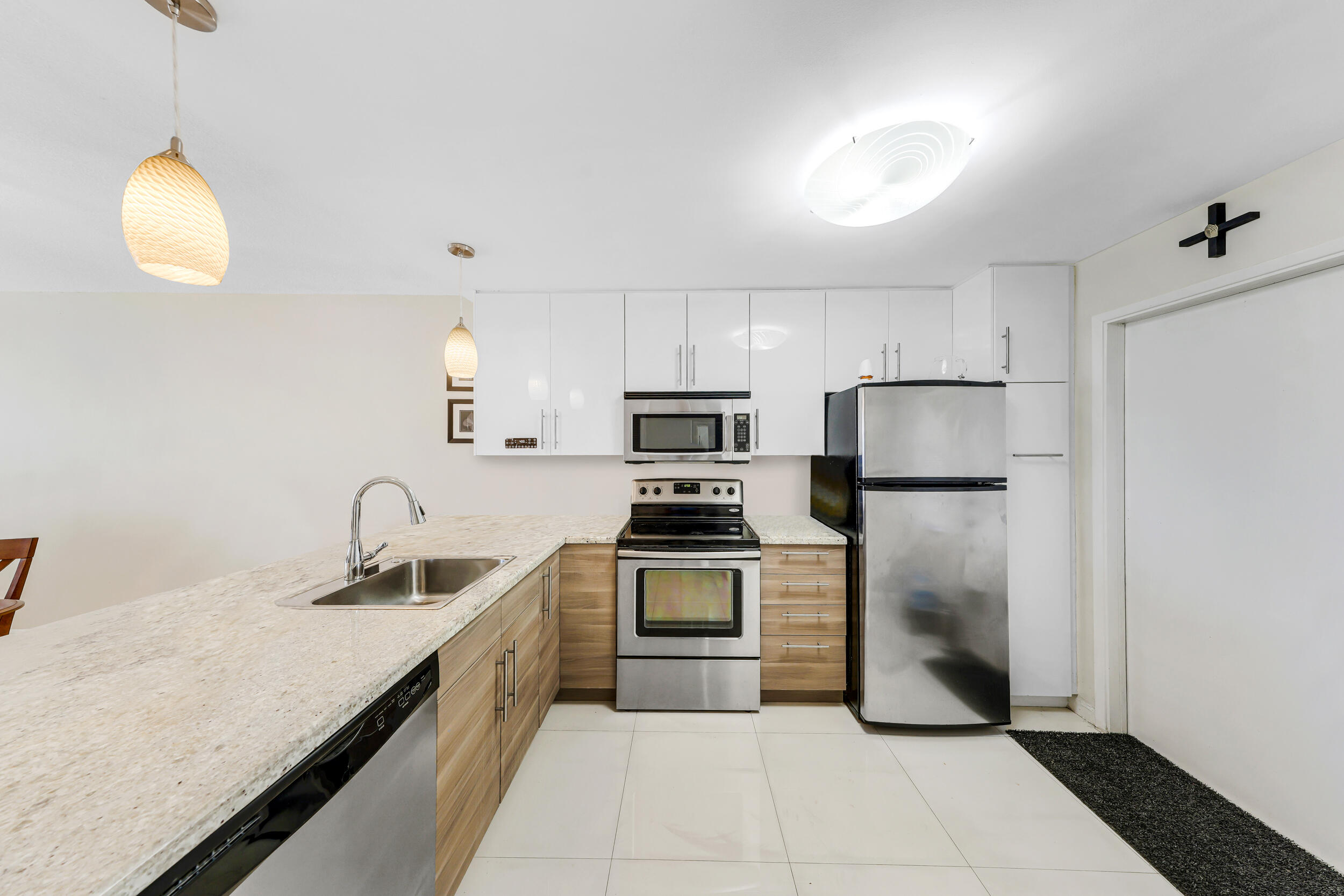 3091 North Course Drive, Unit 102 Pompano Beach, FL 33069 - Photo 4 of 16 a kitchen with refrigerator cabinets and stainless steel appliances
