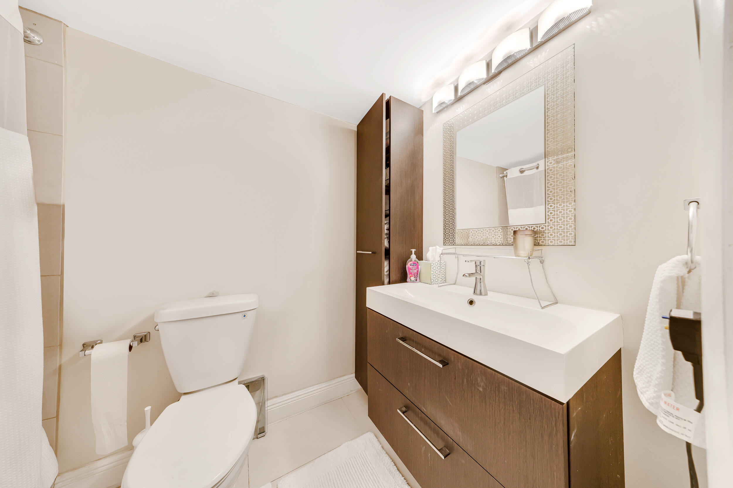 3091 North Course Drive, Unit 102 Pompano Beach, FL 33069 - Photo 6 of 16 a bathroom with a toilet sink and mirror