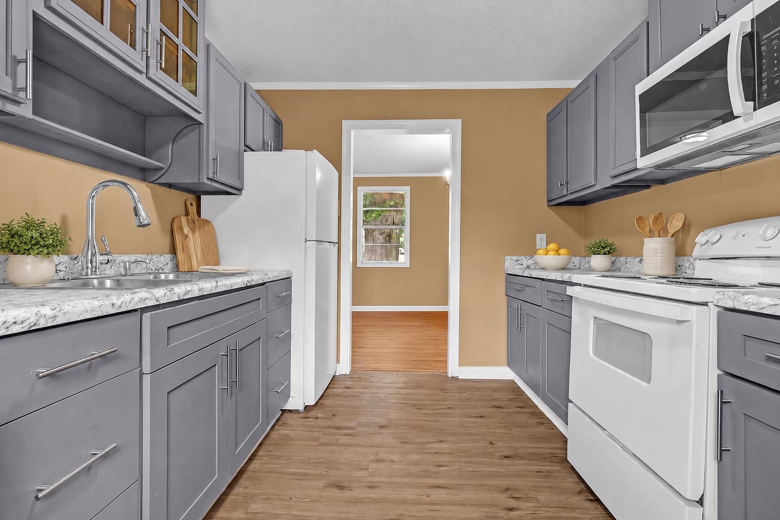 3186 Alta Road Memphis, TN 38109 - Photo 8 of 17 a kitchen with stainless steel appliances granite countertop a sink and cabinets with wooden floor
