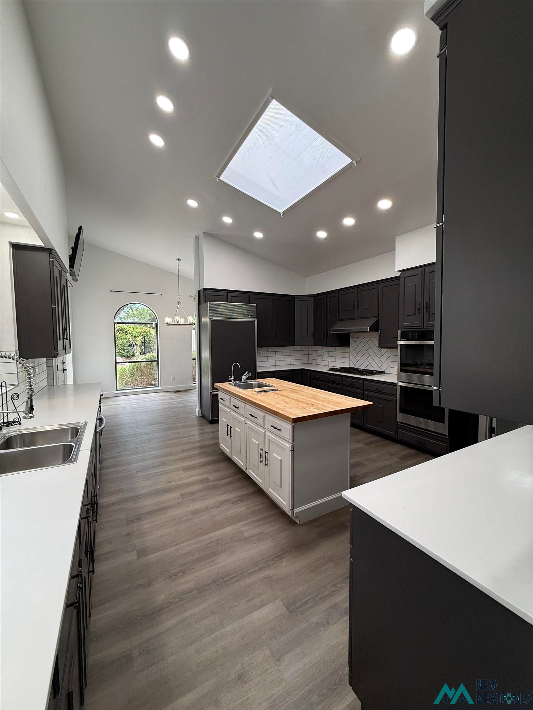 1111 West Country Road Roswell, NM 88201 - Photo 13 of 41 Modern kitchen featuring vaulted ceilings with recessed lighting and a central skylight