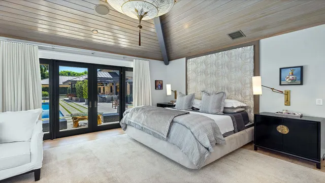 a bedroom with furniture and large windows