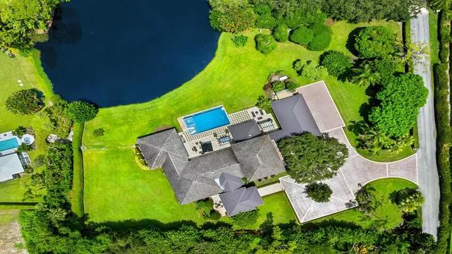 an aerial view of a house with swimming pool and garden
