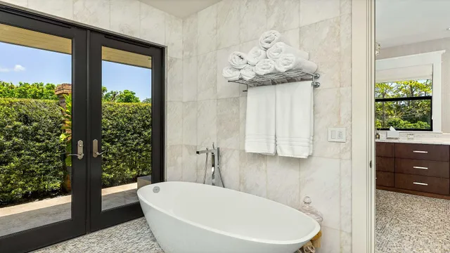 a bathroom with a granite countertop sink a large mirror and a bathtub