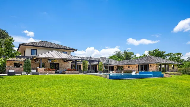 an aerial view of a house with swimming pool and garden