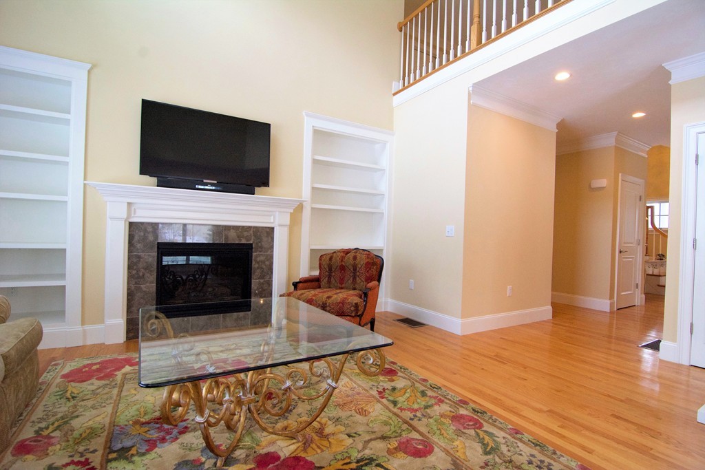 30 Nobscot Road, Unit 24 Sudbury, MA 01776 - Photo 11 of 24 a living room with furniture a flat screen tv and a fireplace