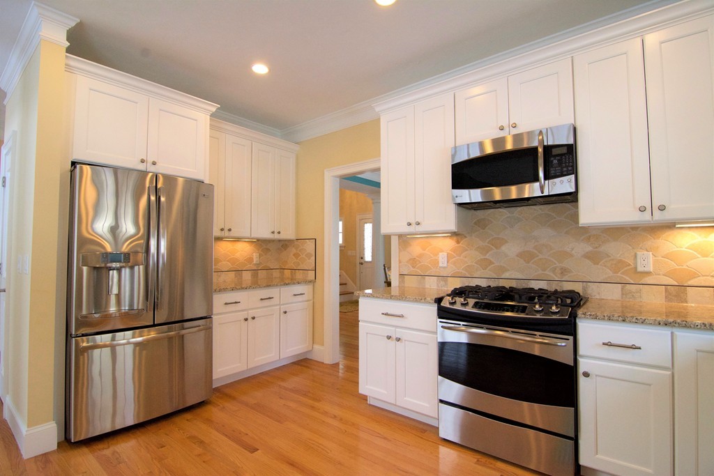 30 Nobscot Road, Unit 24 Sudbury, MA 01776 - Photo 5 of 24 a kitchen with cabinets stainless steel appliances and wooden floor