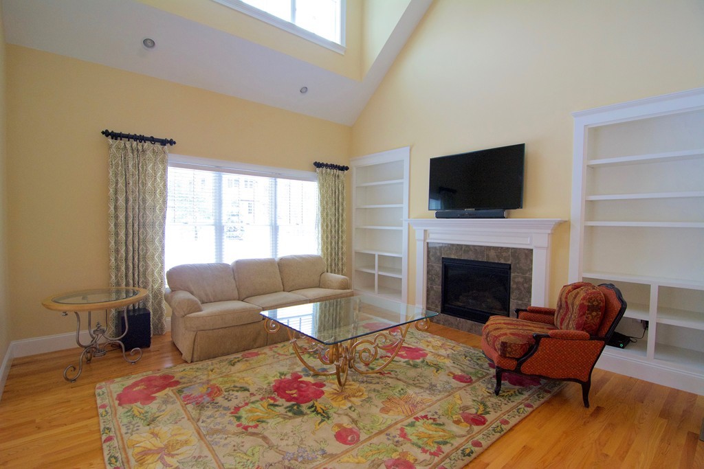 30 Nobscot Road, Unit 24 Sudbury, MA 01776 - Photo 9 of 24 a living room with furniture a fireplace and a flat screen tv