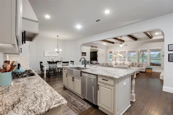 a kitchen with lots of counter and chairs