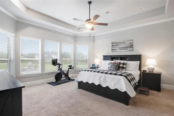a spacious bedroom with a bed and large windows
