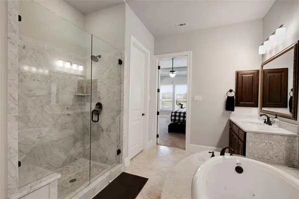 a bathroom with a tub sink mirror and shower