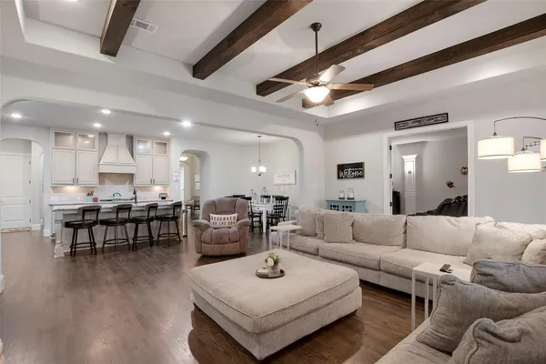 a living room with furniture a wooden floor and a chandelier