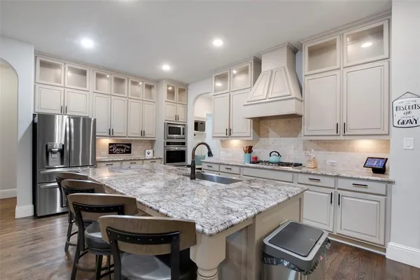 a kitchen with stainless steel appliances granite countertop a sink refrigerator and cabinets
