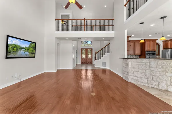 a view of a living room with wooden floor and stairs