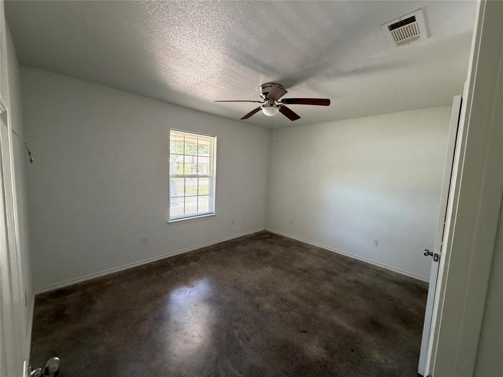 712 Seven Oaks Road, Unit 712 Bonham, TX 75418 - Photo 9 of 14 en empty room with windows and ceiling fan