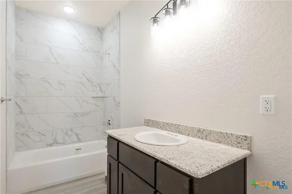 a bathroom with a granite countertop sink toilet and bathtub