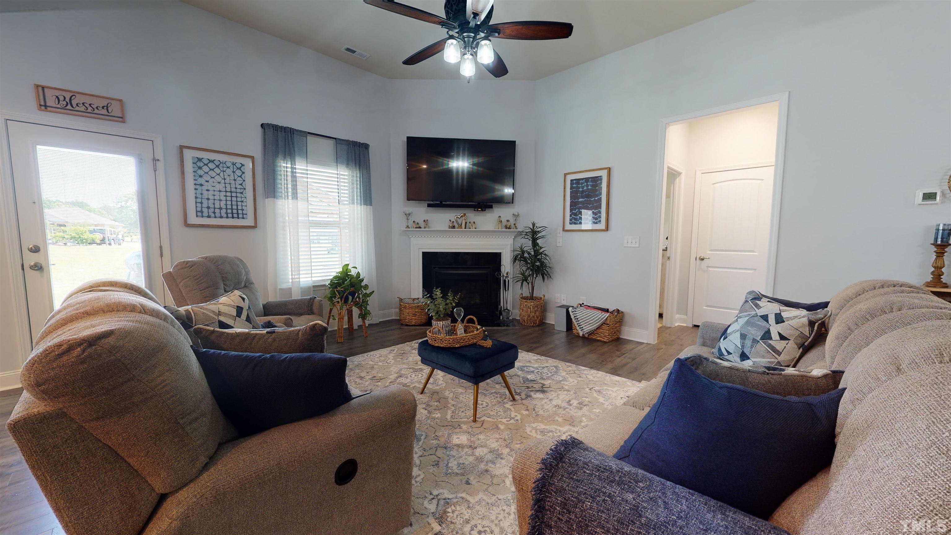 96 Longo Lane Benson, NC 27504 - Photo 14 of 51 a living room with furniture a fireplace and a flat screen tv