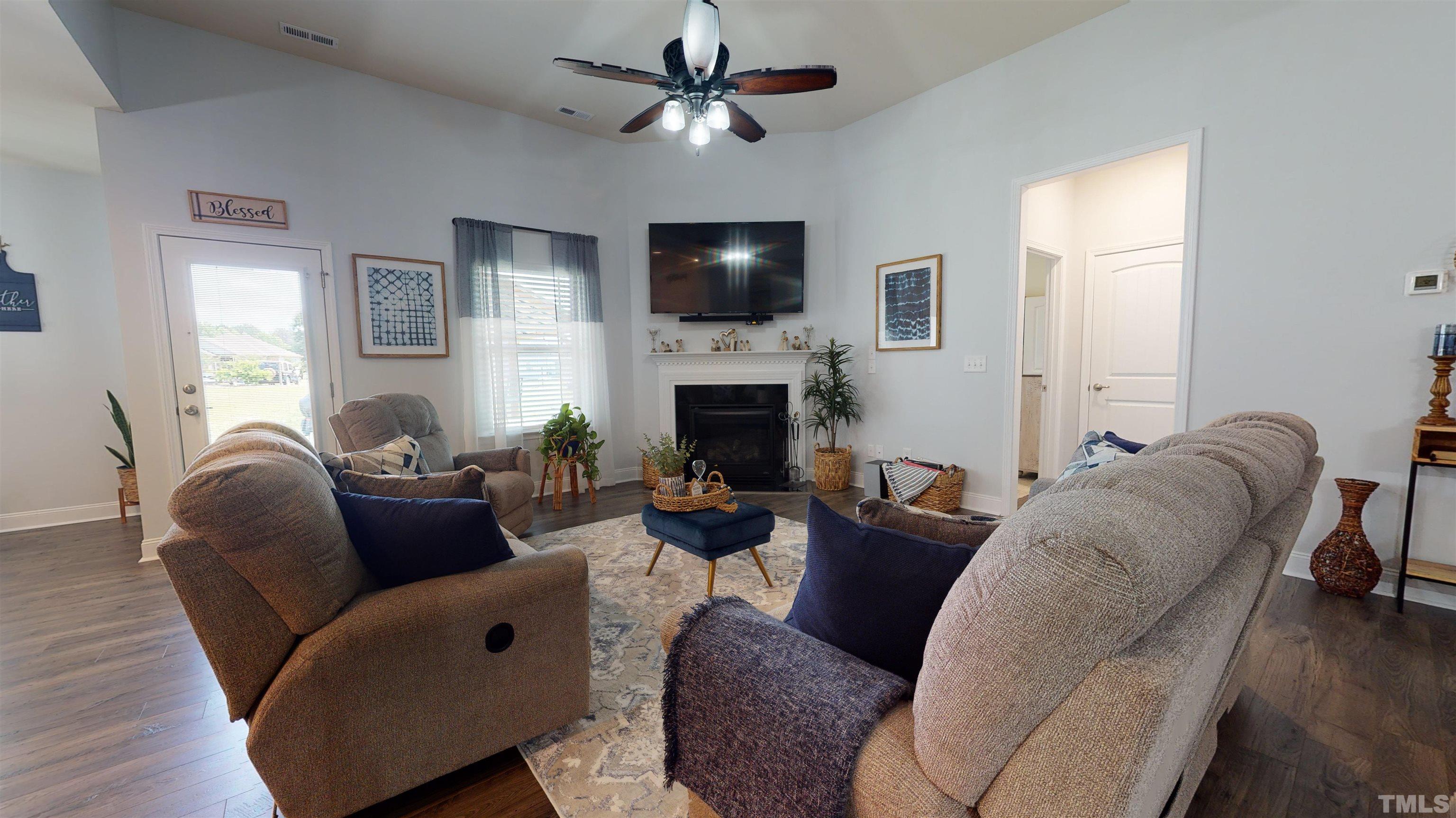 96 Longo Lane Benson, NC 27504 - Photo 23 of 51 a living room with furniture a fireplace and a flat screen tv