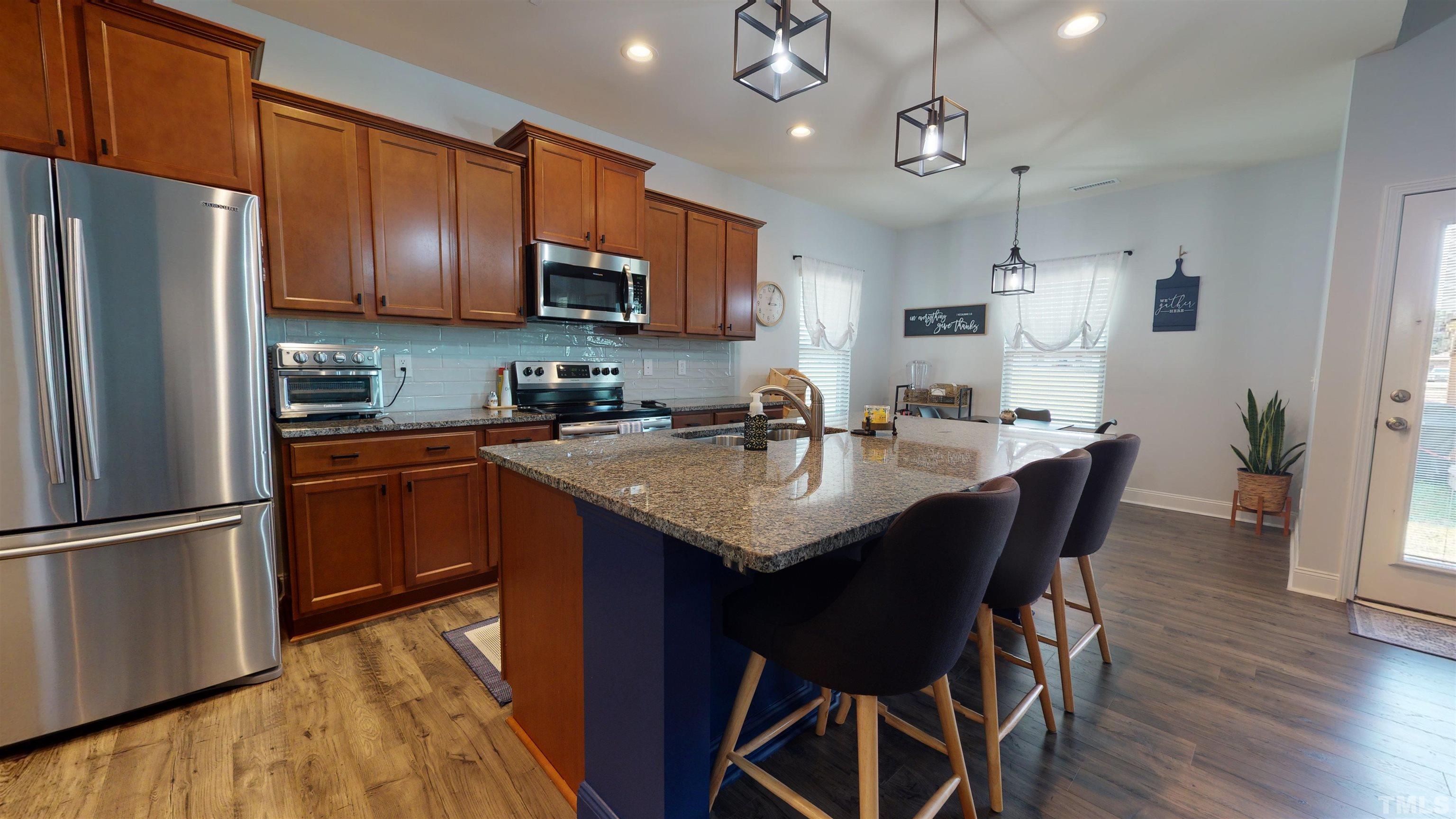 96 Longo Lane Benson, NC 27504 - Photo 24 of 51 a kitchen with granite countertop a sink appliances and wooden floor