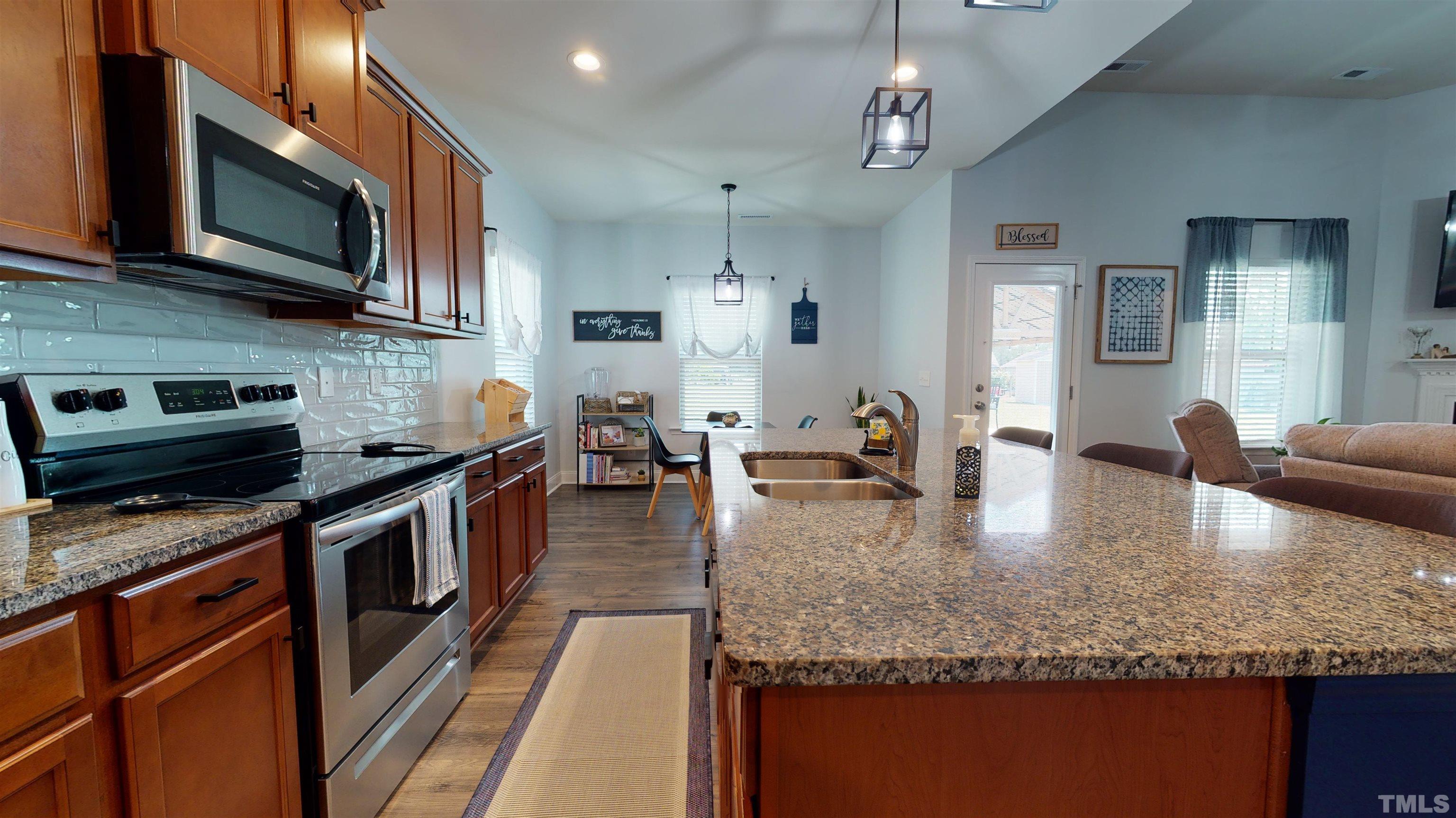96 Longo Lane Benson, NC 27504 - Photo 25 of 51 a large kitchen with kitchen island granite countertop a stove a sink dishwasher and a microwave