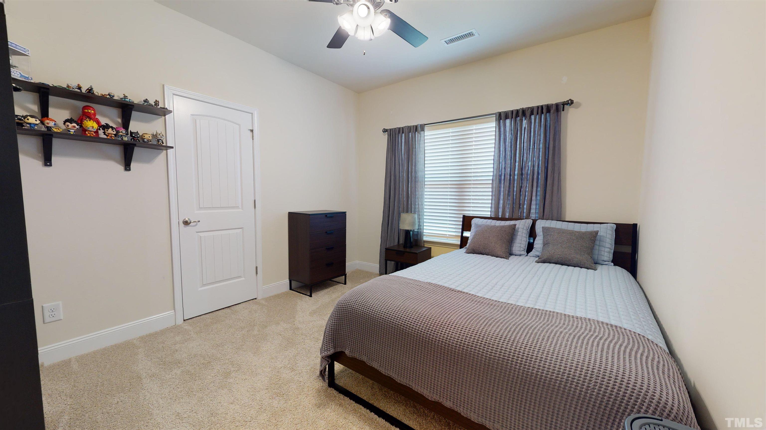 96 Longo Lane Benson, NC 27504 - Photo 33 of 51 a bedroom with a bed and a chandelier