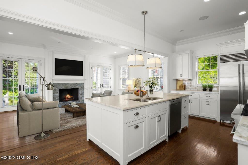 24 Orchard Place, Unit A Greenwich, CT 06830 - Photo 3 of 15 a kitchen with stainless steel appliances granite countertop a stove refrigerator and a fireplace with wooden floor