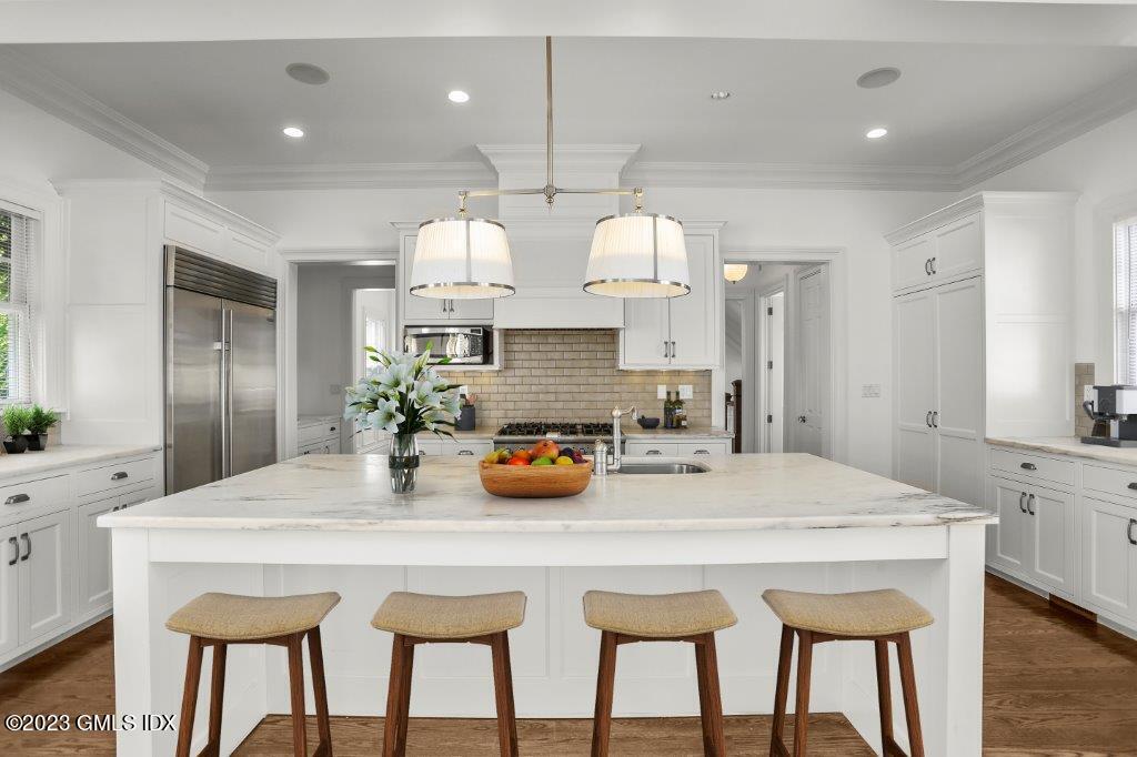 24 Orchard Place, Unit A Greenwich, CT 06830 - Photo 7 of 15 a kitchen with a table a sink cabinets and wooden floor