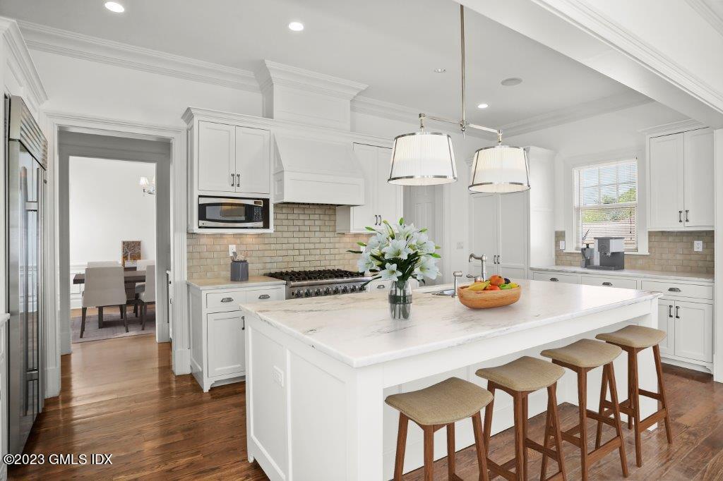 24 Orchard Place, Unit A Greenwich, CT 06830 - Photo 8 of 15 a kitchen with a sink a stove and chairs
