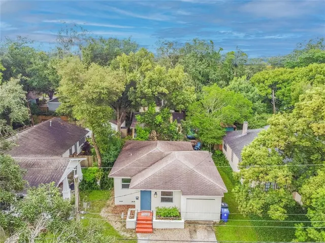 an aerial view of house with yard and trees in the background
