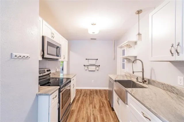 a kitchen with a sink a stove and cabinets