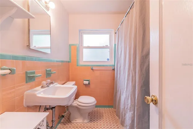 a bathroom with a sink a toilet and a mirror