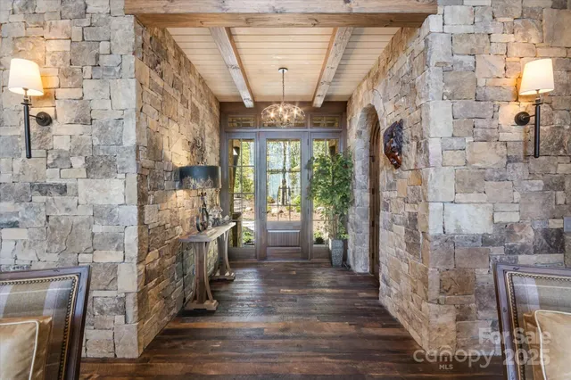 a living room with furniture a fireplace and a floor to ceiling window