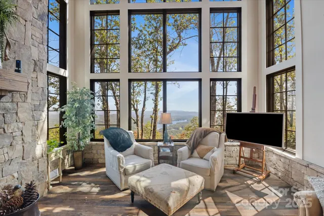a living room with couches painting on wall and a large window