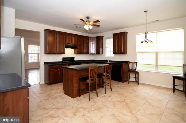 a kitchen with stainless steel appliances granite countertop wooden cabinets and a stove top oven