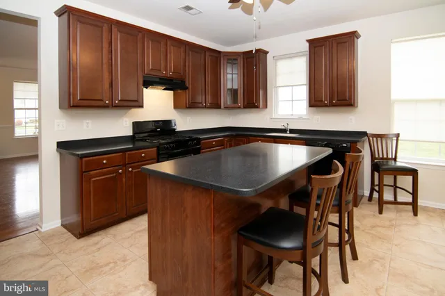 a kitchen with stainless steel appliances granite countertop a sink a refrigerator and a stove