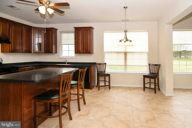 a kitchen with stainless steel appliances granite countertop a sink dishwasher stove and refrigerator with wooden floor
