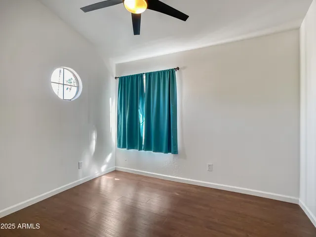 an empty room with a hardwood and wooden door